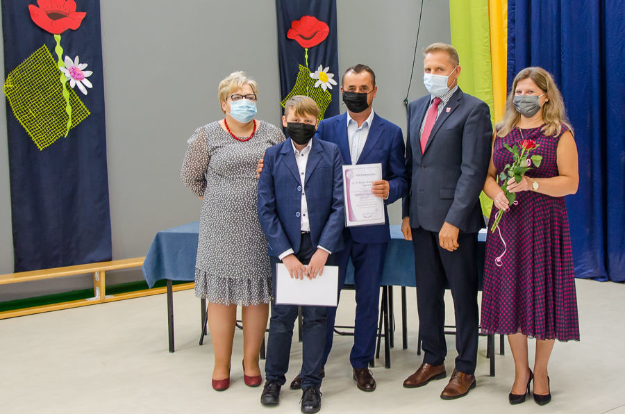 Zdjęcie stypendysty z zastępca wójta i dyrektorkami placówki