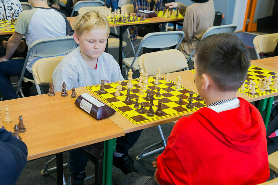 Stół przy którym dzieci rozgrywają partie szachowe