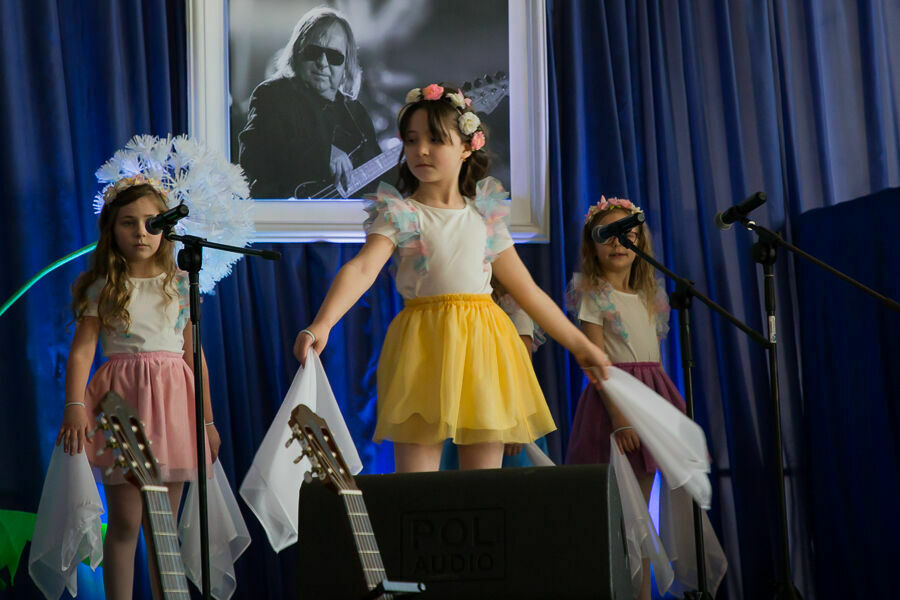 trzy dziewczynki na scenie w kolorowych strojach