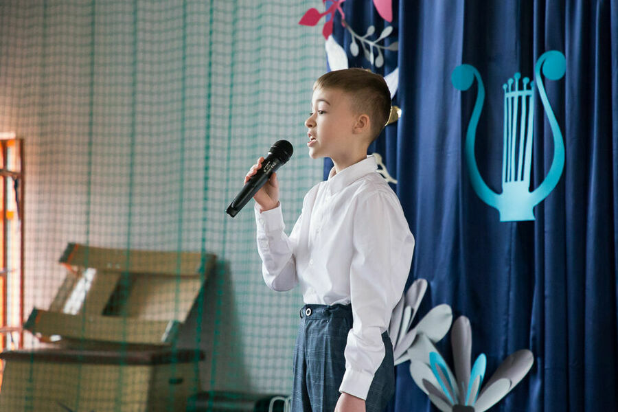 chłopiec z mikrofonem na scenie