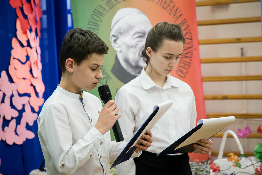 chłopiec wraz z dziewczynką witają przybyłych na uroczystość