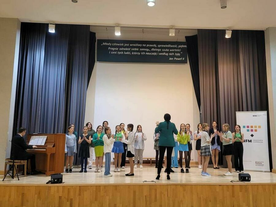 grupa dzieci z dyrygentem na scenie