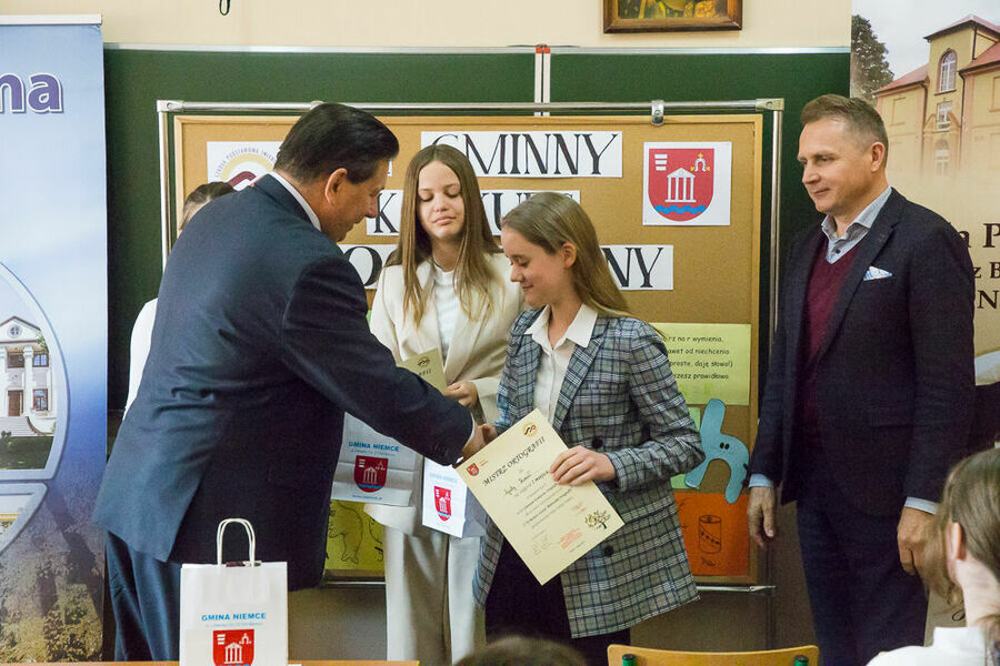 Dyrektor szkoły oraz zastępca wójta gminy Niemce wręczający dyplomy