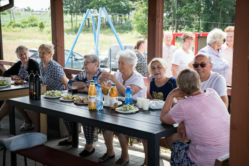 seniorzy siedzą przy stołach