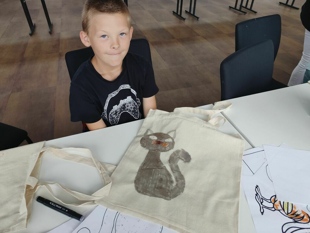 Chłopiec z wykonanym rysunkiem na torbie