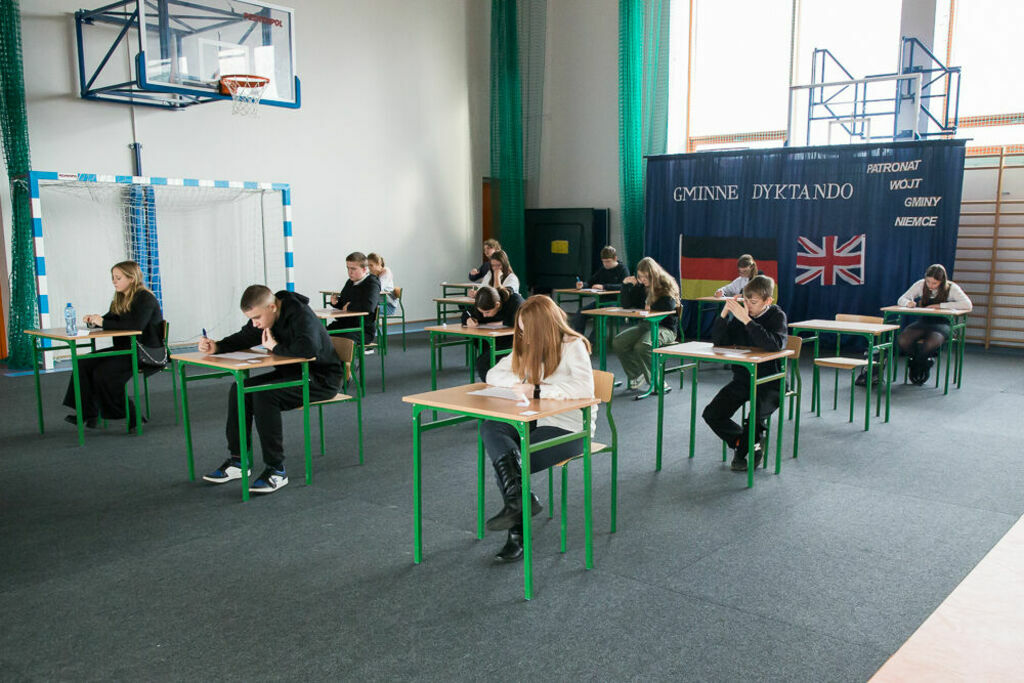 uczniowie w ławkach piszący dyktando