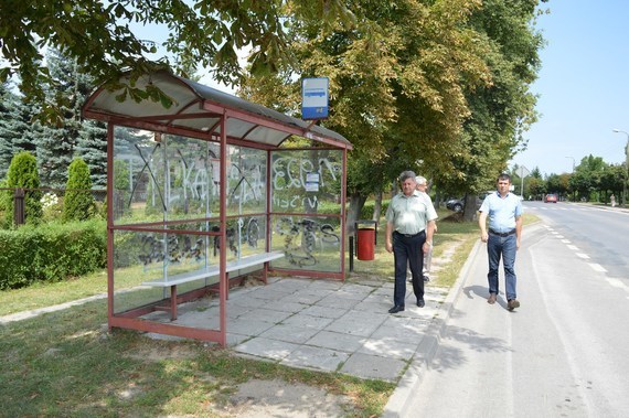 
                                                    3 osoby przy przystanku autobusowym
                                                