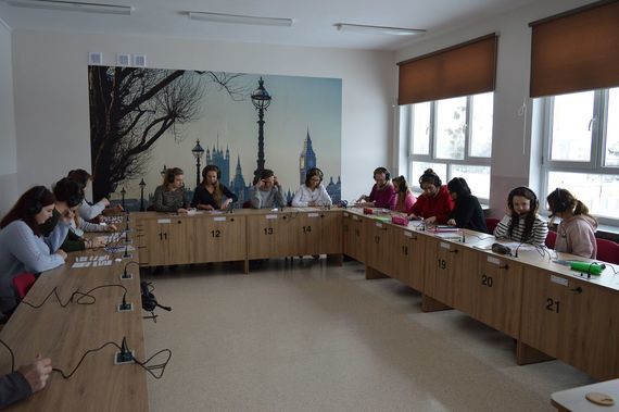 
                                                    Grupa osób siedzących w słuchawkach
                                                