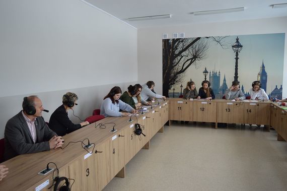
                                                    Grupa osób siedzących w słuchawkach
                                                