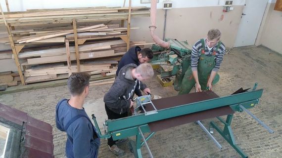 
                                                    Grupa osób przy giętarce blachy
                                                