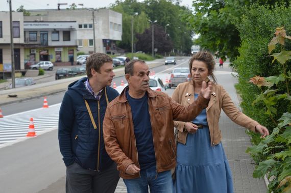 
                                                    Grupa osób przy ulicy na tle samochodów
                                                