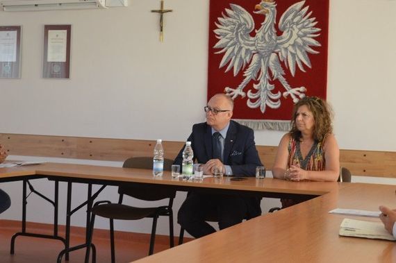 
                                                    2 osoby siedzące na tle godła
                                                