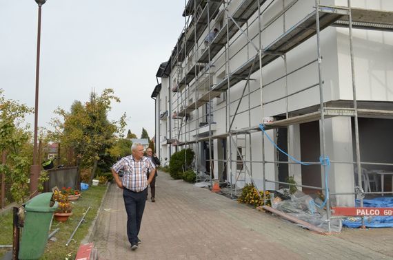 
                                                    2 osoby przy budynku w remoncie
                                                