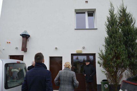 
                                                    Ludzie przy budynku domu pomocy społecznej
                                                