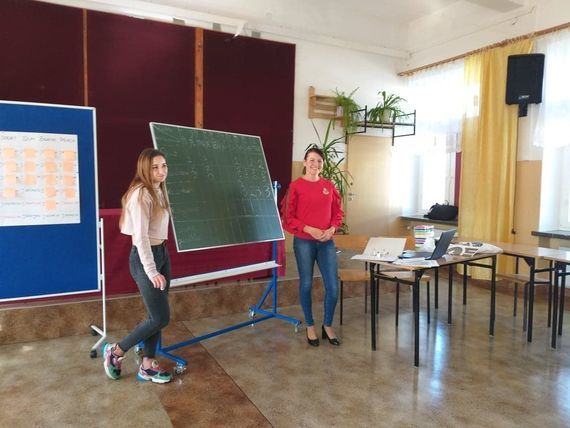 
                                                    Dwie osoby przy tablicy wyników
                                                