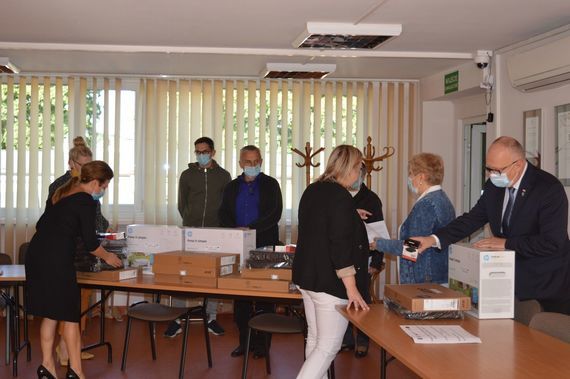 
                                                    Grupa osób przy sprzęcie komputerowym
                                                