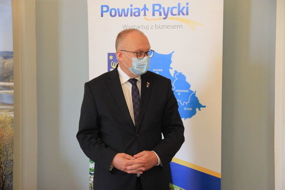 
                                                    Zdjęcie uczestników spotkania na tle rollupów
                                                