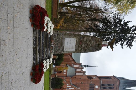 
                                                    Pomnik, wokół biało-czerwone chryzantemy
                                                