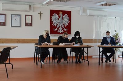 
                                                    Osoby siedzące przy biurkach podczas otwarcia ofert
                                                