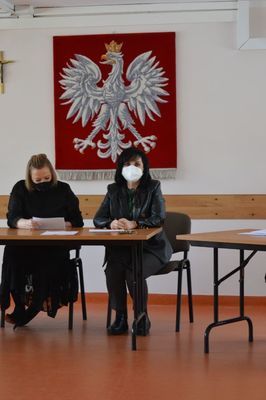 
                                                    Osoby siedzące przy biurkach podczas otwarcia ofert
                                                