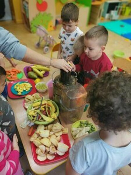 Dzieci z przedszkola przygotowują sok z owoców
