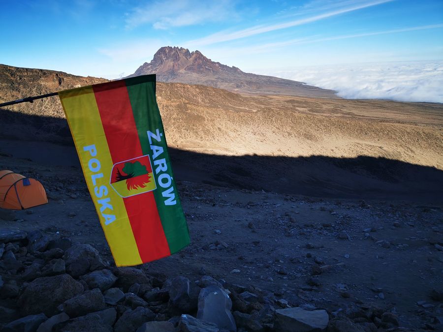 Marek Madera z flagą gminy Żarów na Kilimandżaro