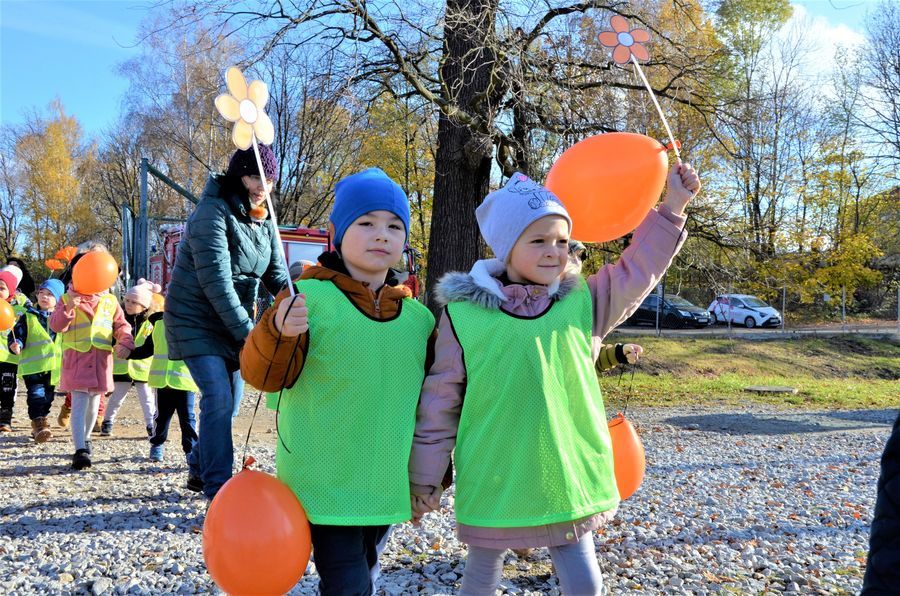 przedszkolaki z pomarańczowymi balonikami