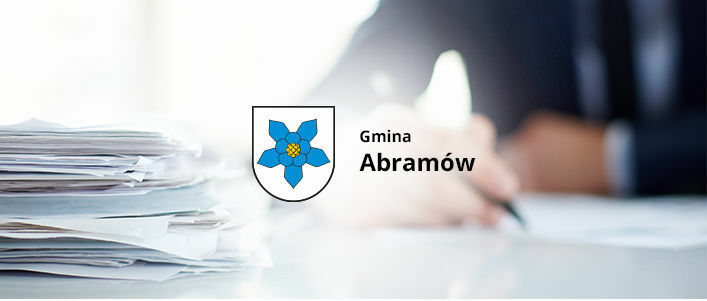 Herb Gminy Abramów na tle osoby podpisującej dokument