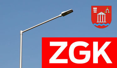 Zdjęcie przedstawia napis zgk i herb gminy Niemce na tle latarni ulicznej