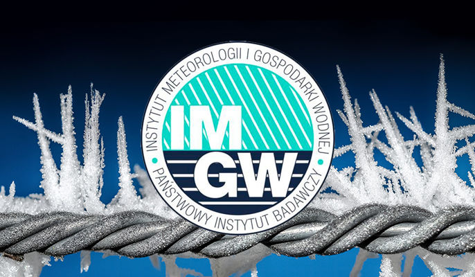 Na zdjęciu logo IMGW na tle oszronionego drutu