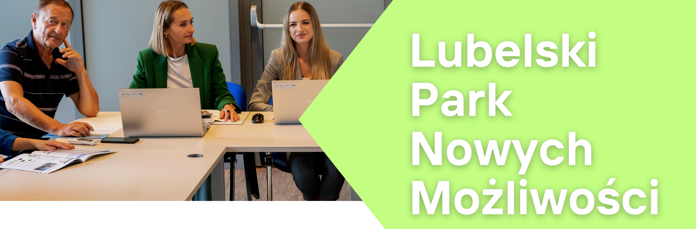 Trzy osoby, dwie kobiety i mężczyzna, siedzą przy stole z laptopami w biurowym otoczeniu, z napisem "Lubelski Park Nowych Możliwości".
