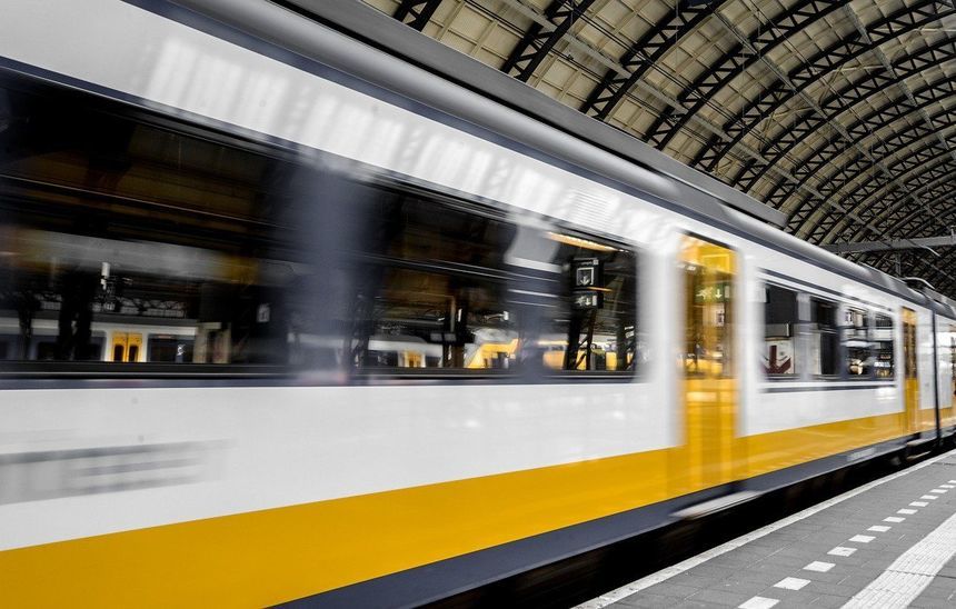 na zdjęciu biało-żółty jadący pociąg