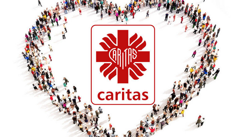 napis Caritas w sercu