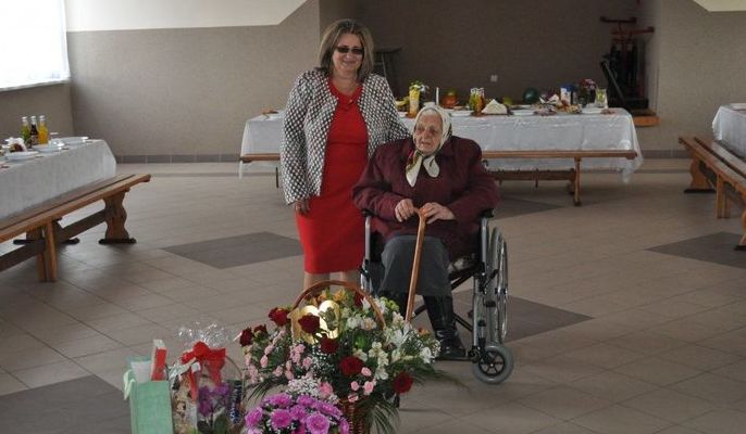Pani Janina w wózku z bukitami kwiatów
