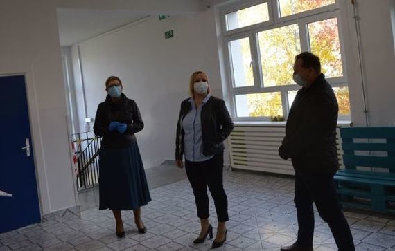 Trzy osoby w maseczkach podczas odbierania budynku