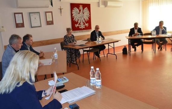 Grupa ludzi siedzących przy stolikach na sali