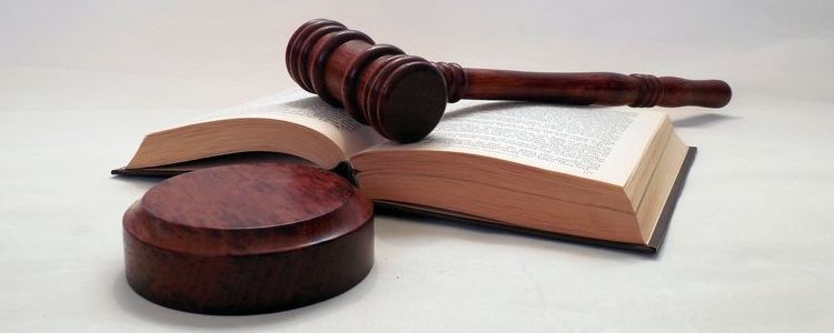 Symbolika wymiaru sprawiedliwości - młotek sędziowski na otwartej księdze.