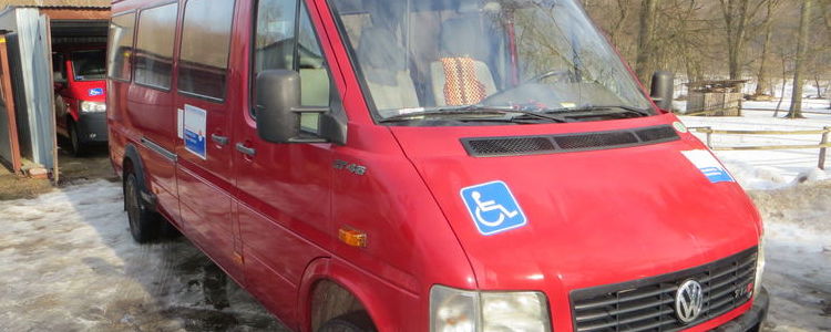 czerwony bus dla osób niepełnosprawnych, w tle garaż, zima