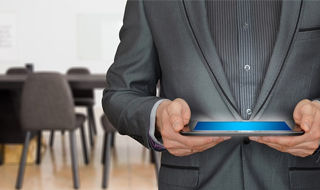 grafika ogólna-sesja: mężczyzna trzymający tablet, w tle sala konferencyjna