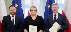 Trzy osoby stojące obok siebie, trzymające dokumenty z godłem, z flagami UE i Polski w tle.