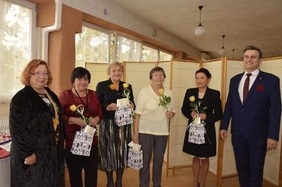 Grupa nauczycieli z kwiatami