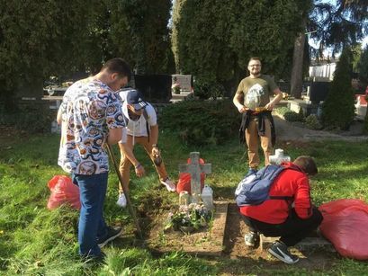 Uczniowie sprzątający groby