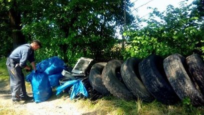 Pan Waldek pakujący śmieci do worka
