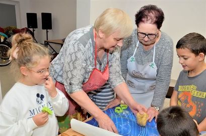Członkowie Stowarzyszenie Miłośników Łażan "Przyjazna Wieś" z dziećmi podczas warsztatów kulinarnych