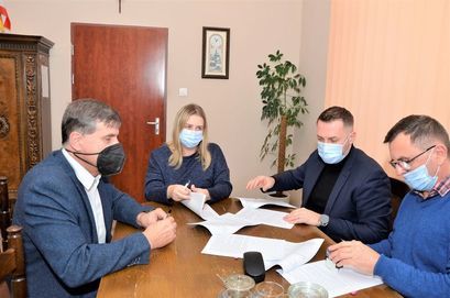 Burmistrz Leszek Michalaka, zastępca burmistrza Przemysław Sikora i wykonawca inwestycji podpisują umowę na remont dróg