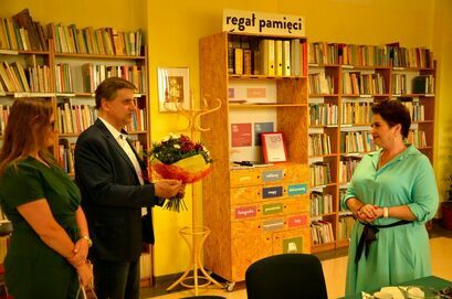 Burmistrz Leszek Michalak oraz sekretarz gminy Sylwia Pawlik składają życzenia na ręce dyrektor biblioteki Wioletty Kwiatkowskiej