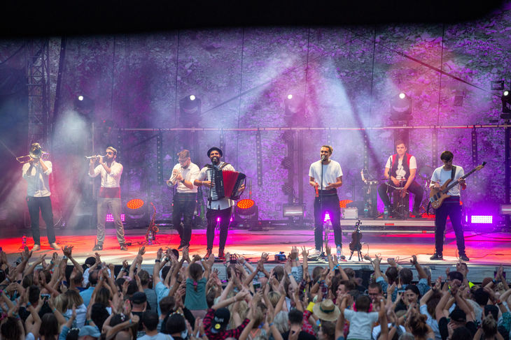 Festiwal Kazimiernikejszyn - koncert. Zdjęcie zespołu występującego na scenie. U dołu zdjęcia widać tłum ludzi pod sceną