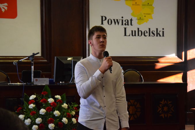 uczeń czyta wiersz na sali konferencyjnej podczas sesji powiatu lubelskiego