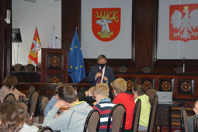 zdjęcie przedstawia uczniów biorących udział w lekcji ze starostą oraz sekretarza Artura Rumińskiego