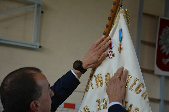 dyrektor przypinający srebrną odznakę honorową Gryfa Zachodniopomorskiego